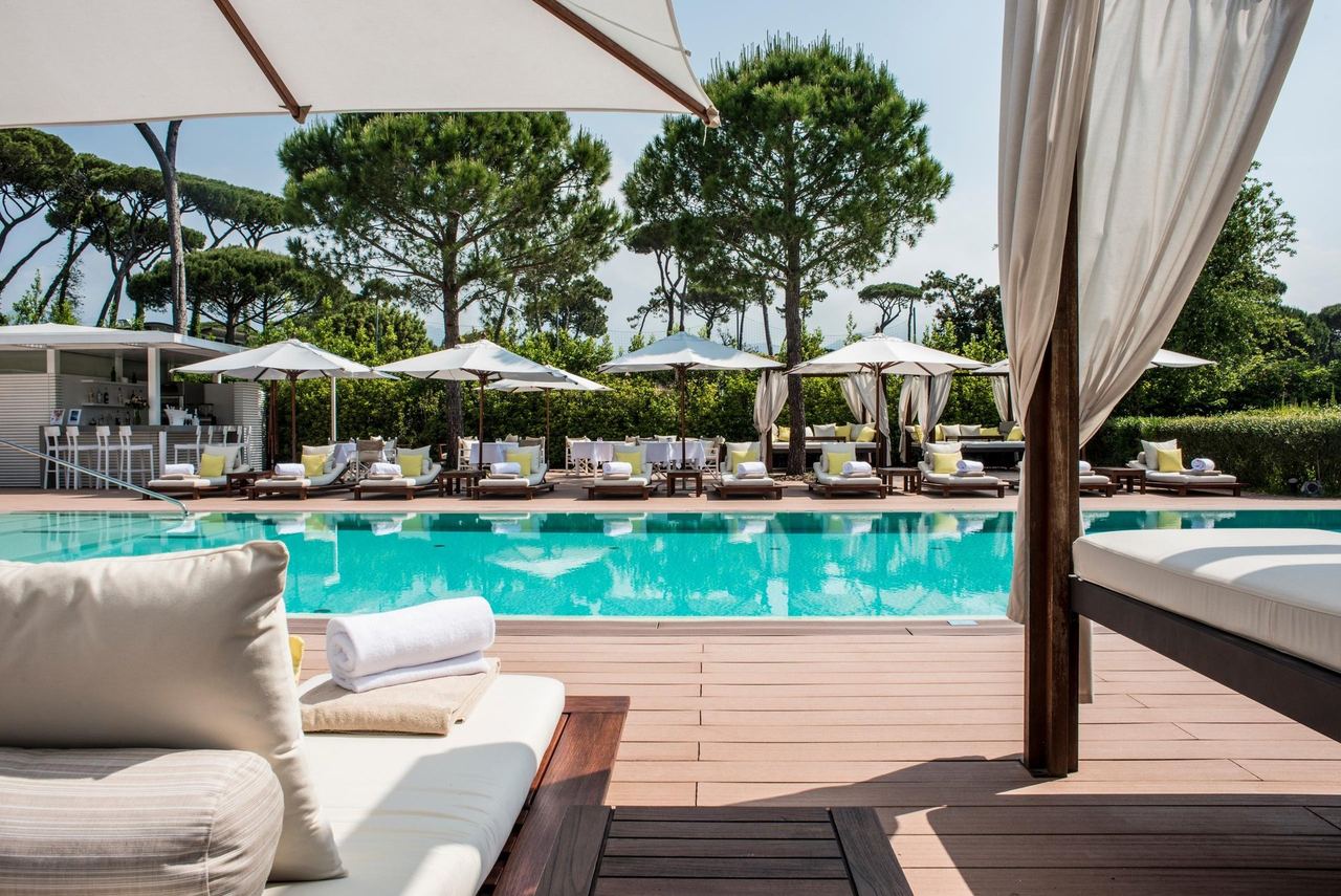The pool and cabanas at Principe Forte dei Marmi, under umbrella pines