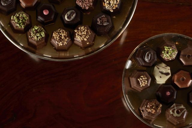 Rivoire’s hand-made chocolates on glass dishes on a dark wooden table
